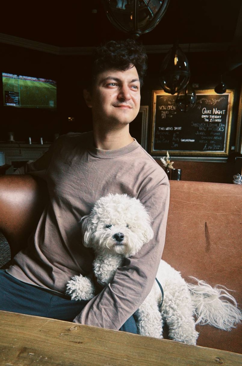 Vladimir Avetian sitting with a small white dog